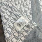 Close-up: gray and white monogram sweatshirt with care label sewn at seam.
