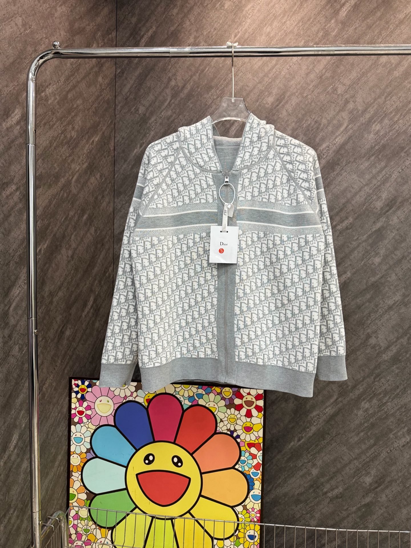 White hooded zip sweatshirt with allover monogram pattern and gray stripe hem.