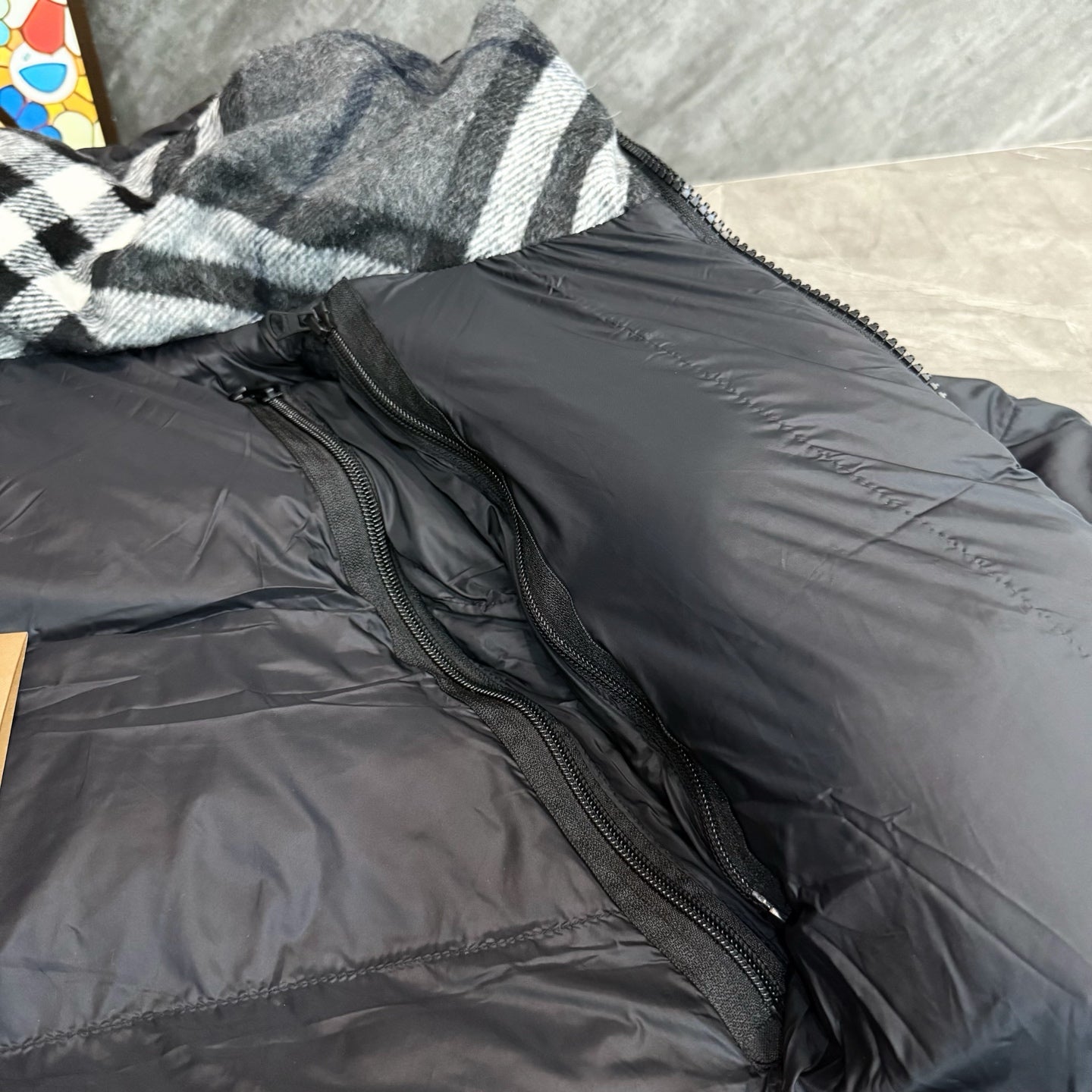 Dark puffer parka with front zipper and side pocket openings