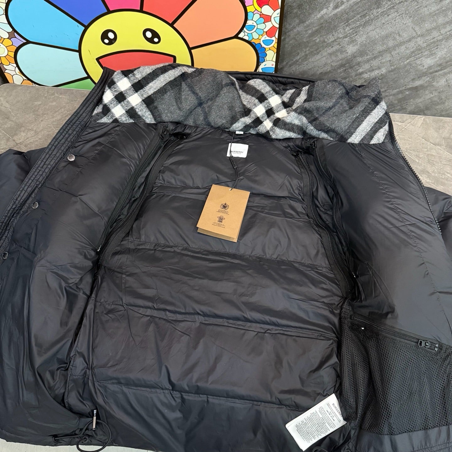Dark puffer parka with plaid hood lining and front interior label