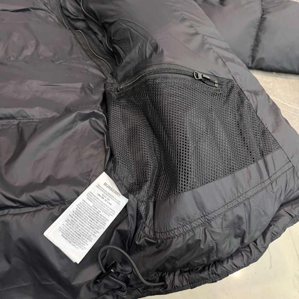 Dark puffer jacket with zip pocket and perforated mesh panel