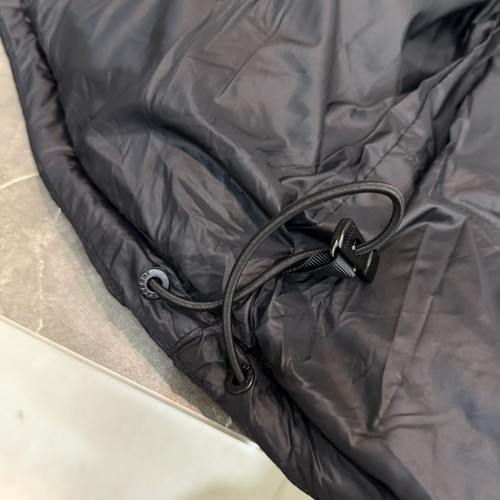 Dark puffer jacket hem with twin drawcords and cord toggles