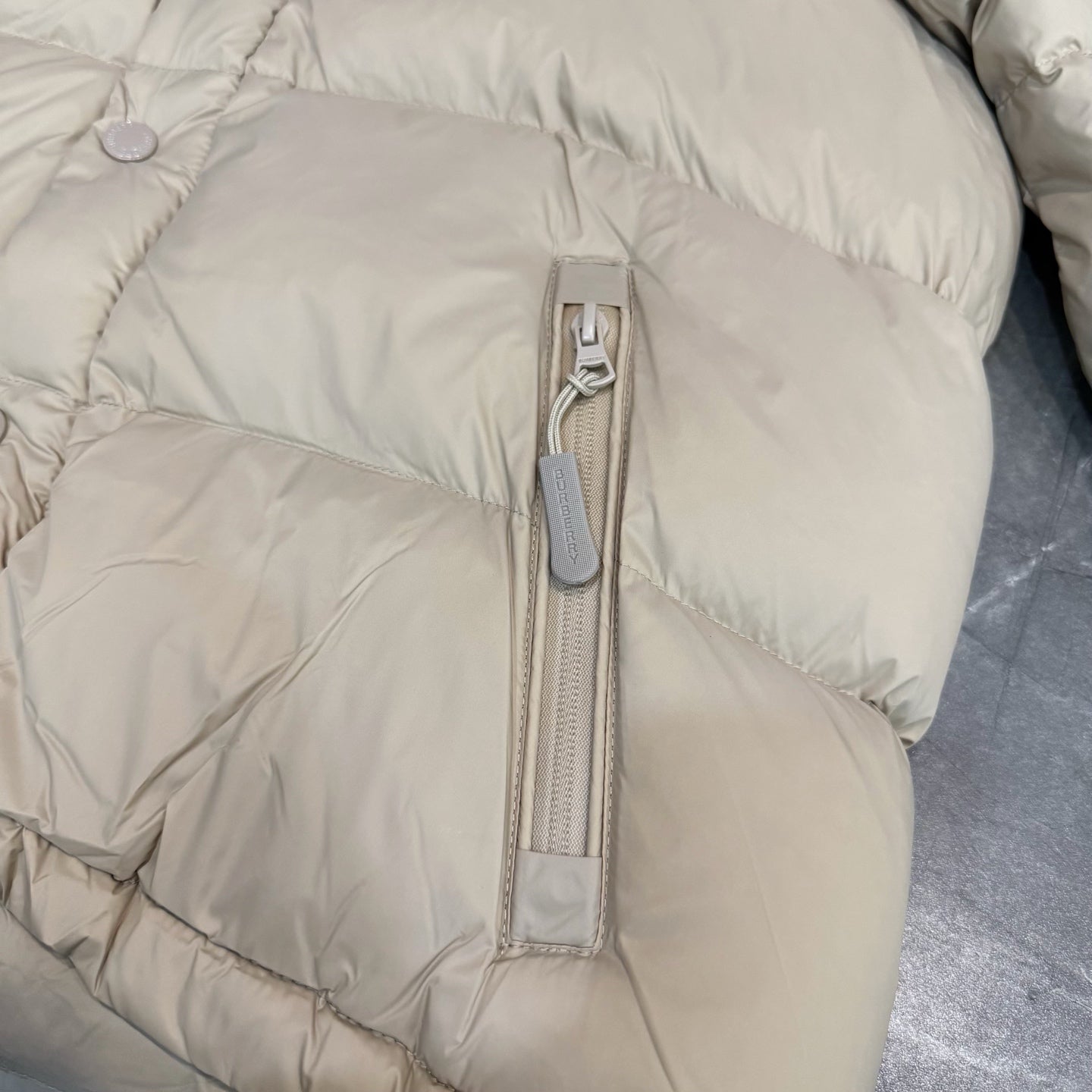 Burberry puffer jacket, light beige with center zip and snap-button placket.