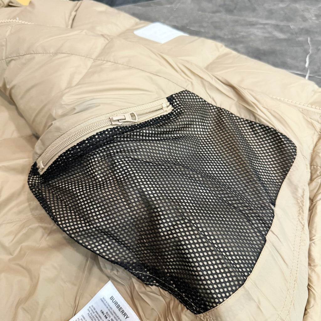 Burberry puffer jacket, light beige with black mesh inner pocket opening.