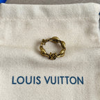 Louis Vuitton gold-tone chain bracelet on white pouch