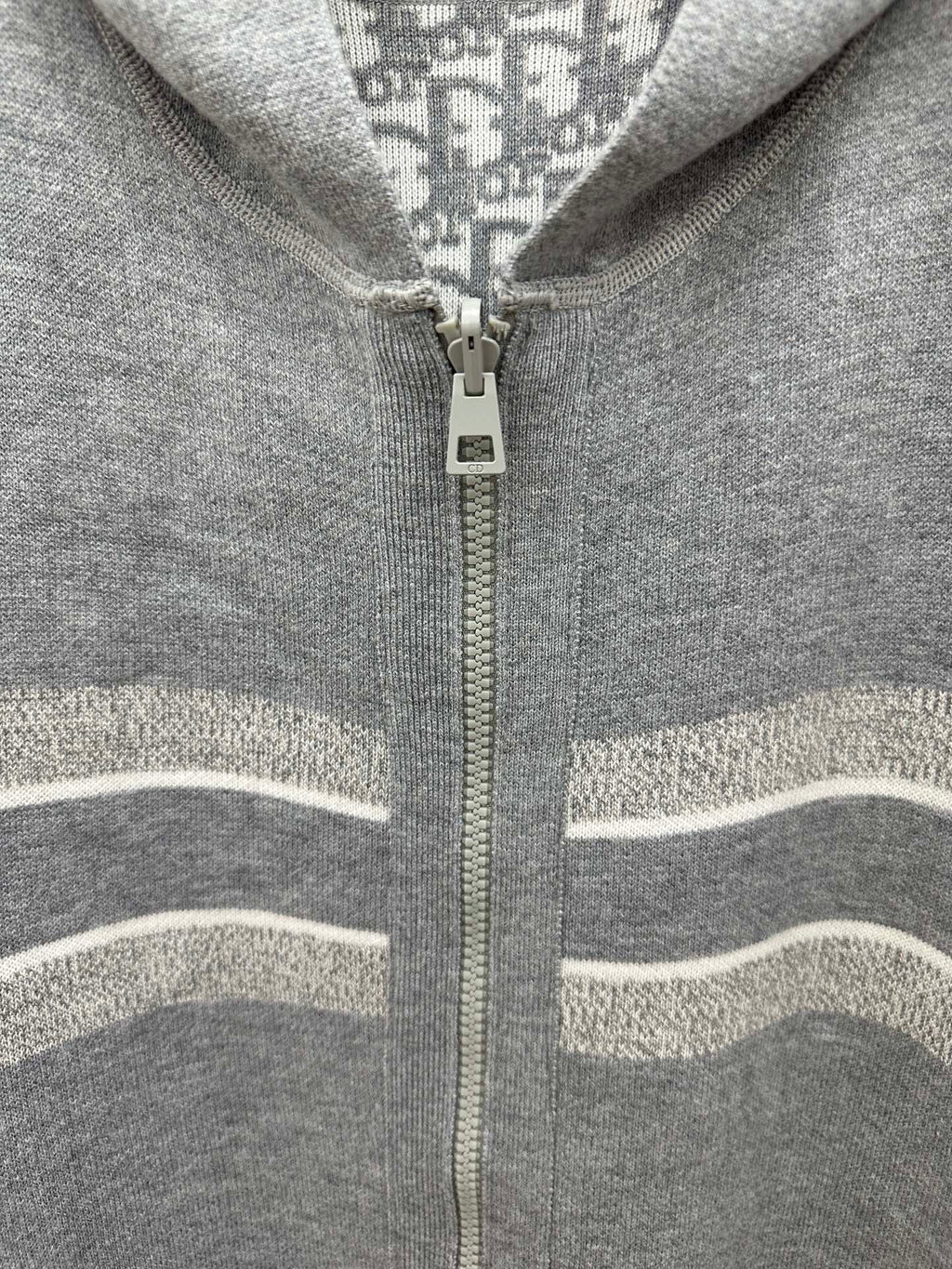 Heather gray zip hoodie detail with centered zipper and striped knit trim