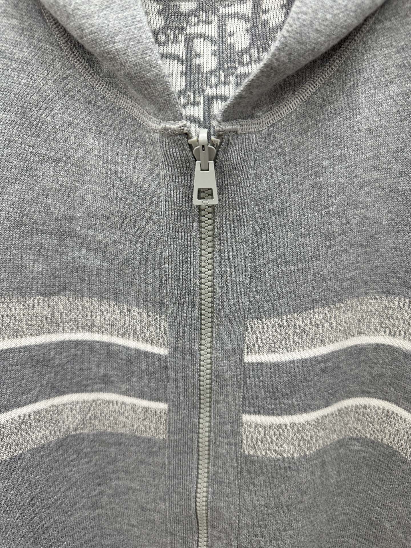 Heather gray zip hoodie detail with centered zipper and striped knit trim