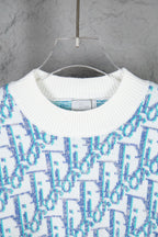 Dior knit sweater close-up: ribbed crew neck with blue and white logo pattern