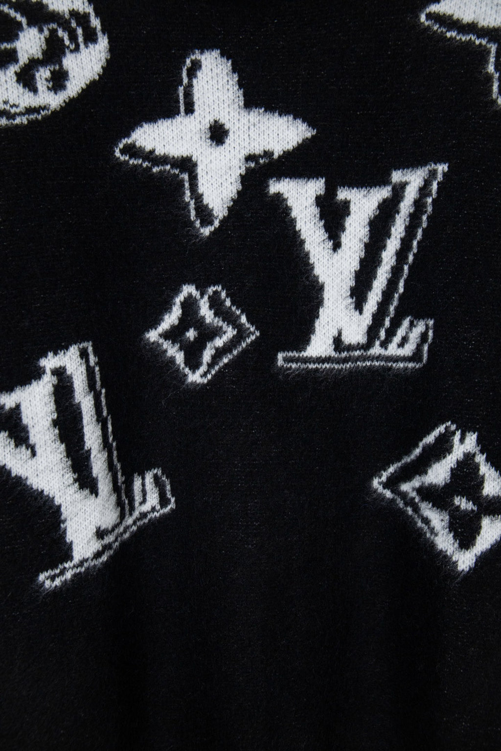 Louis Vuitton sweater close-up, black knit with white star and LV-style graphics