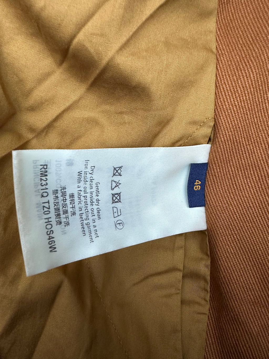 Louis Vuitton care label and size tag stitched inside brown jacket lining