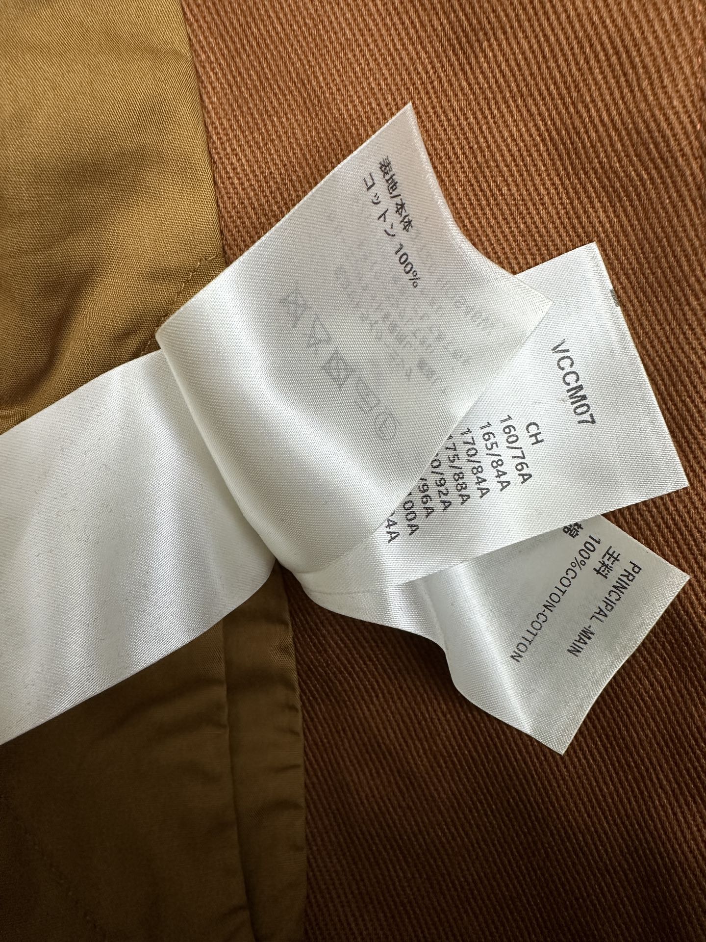 Louis Vuitton composition label on white tag inside brown fabric garment