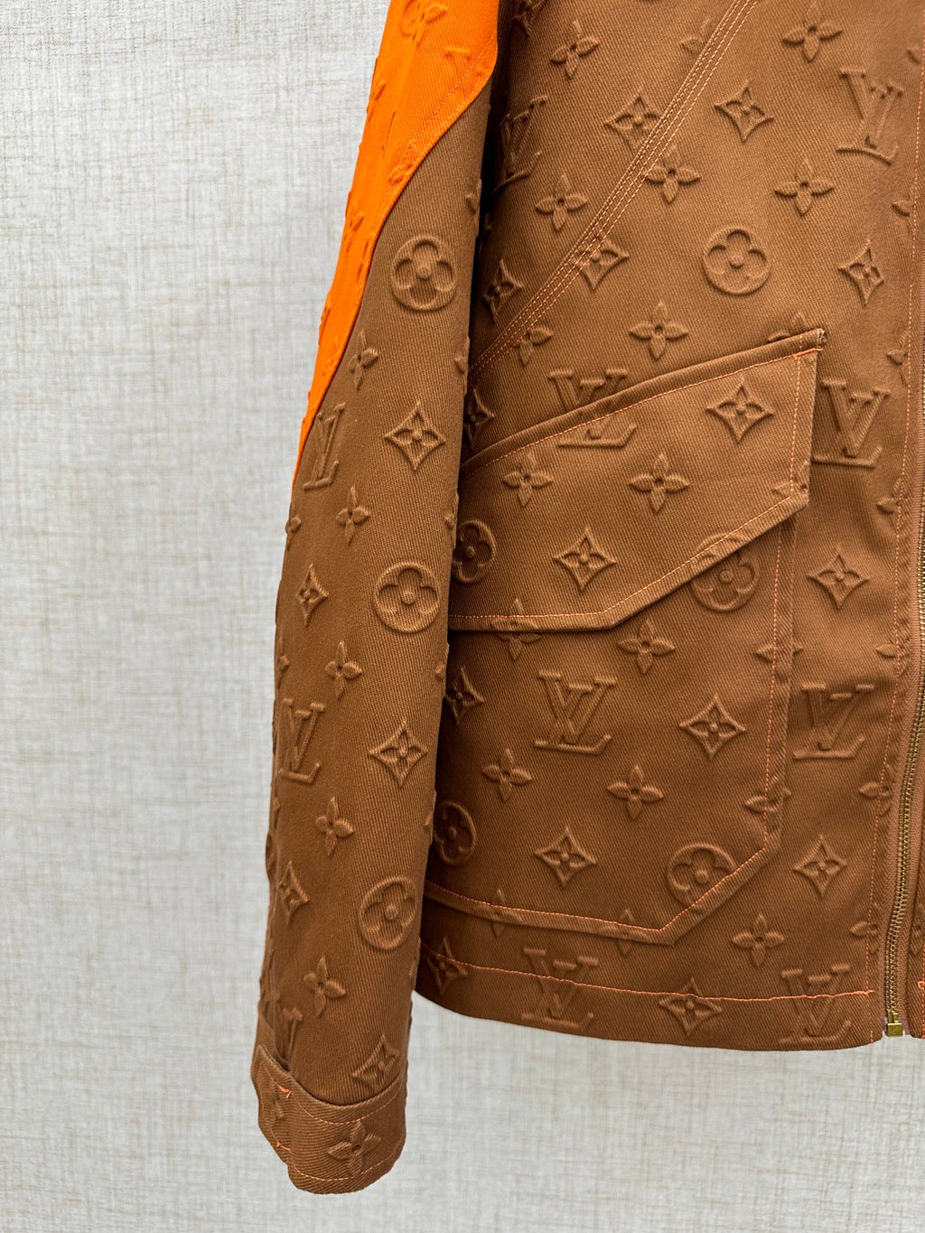 Louis Vuitton brown monogram jacket pocket flap with orange-trimmed collar