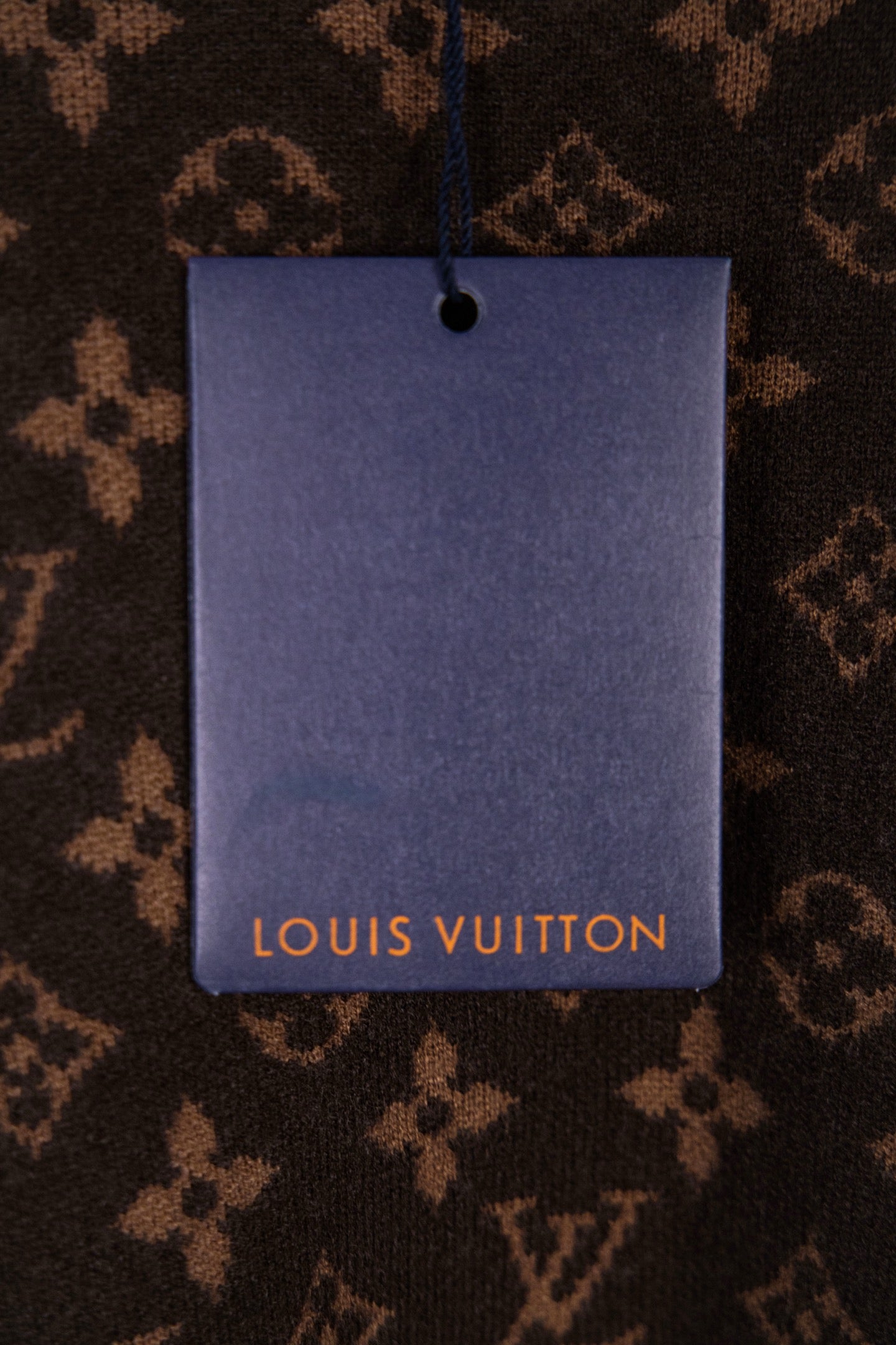 Louis Vuitton clothing tag on dark brown monogram knit fabric