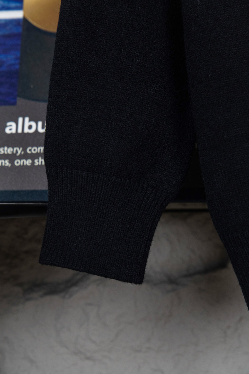 Black knit sweater cuff and hem detail, ribbed long sleeve