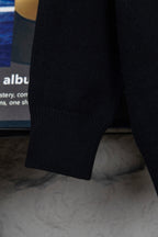 Black knit sweater cuff and hem detail, ribbed long sleeve