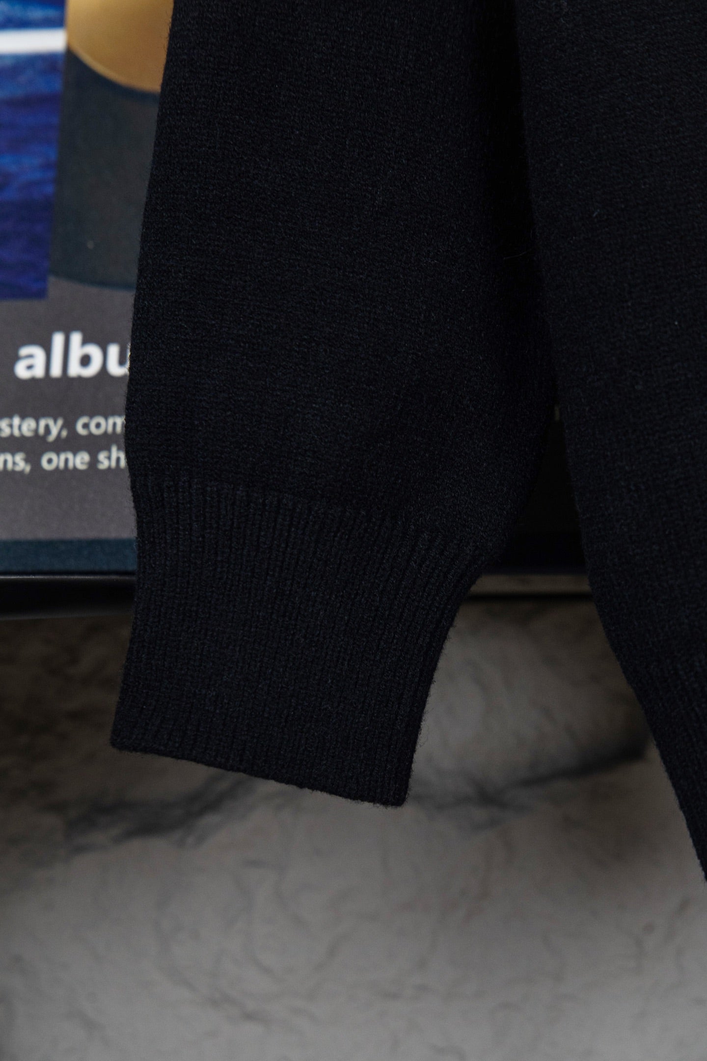 Black knit sweater cuff and hem detail, ribbed long sleeve