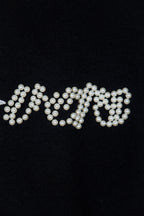 Black knit sweater with pearl-embellished lettering across the chest
