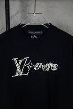 Black long-sleeve knit sweater close-up with rhinestone LV-style chest lettering