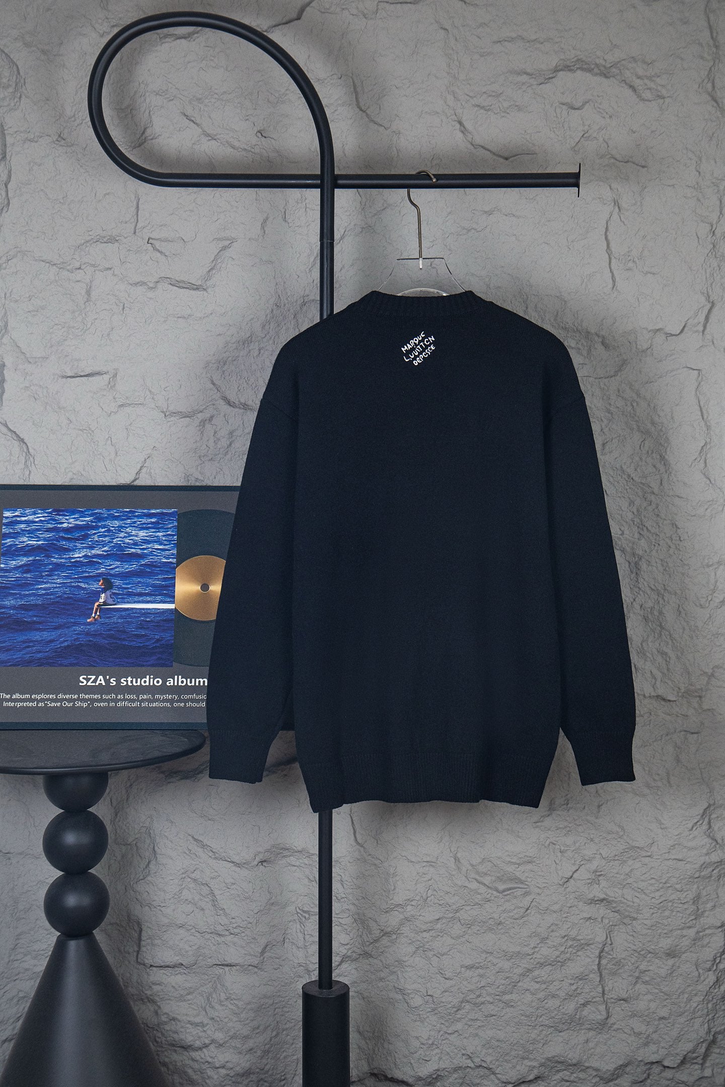 Dark long-sleeve knit sweater with small center logo on back
