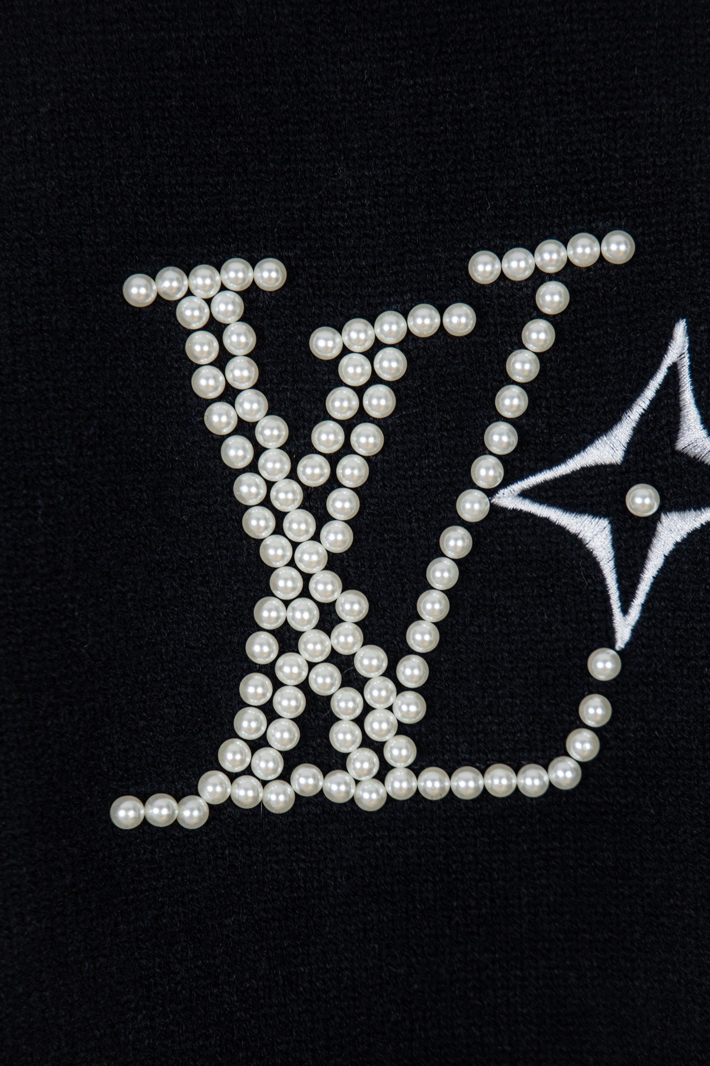 Black knit sweater with large pearl-embellished lettering and star motif