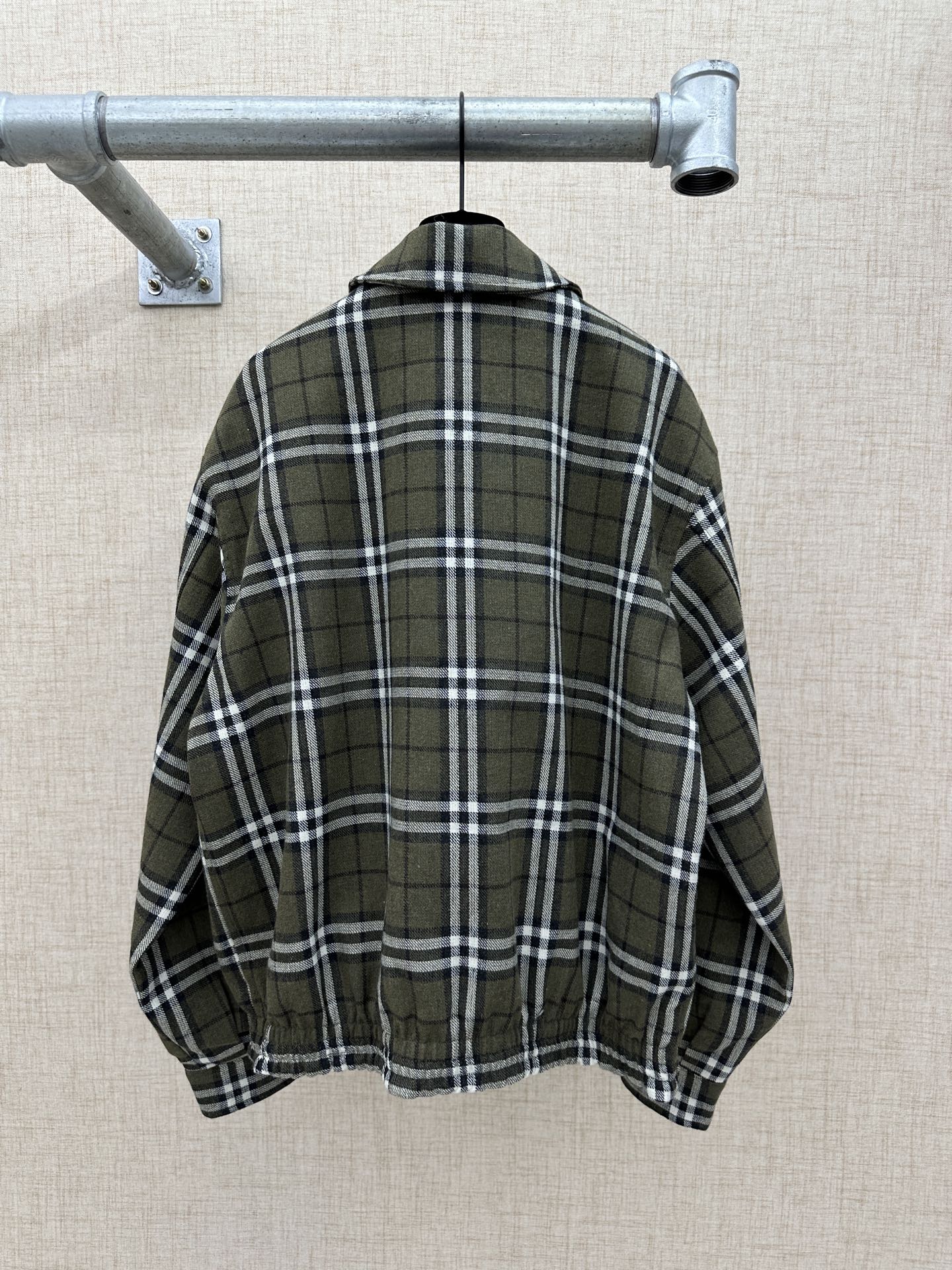 Olive green plaid jacket back view with stand collar and elastic hem
