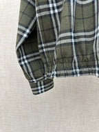 Olive green plaid jacket sleeve with elastic cuff and stitched hem edge