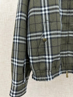 Olive green and black plaid jacket sleeve with cuff and stitched front pocket detail