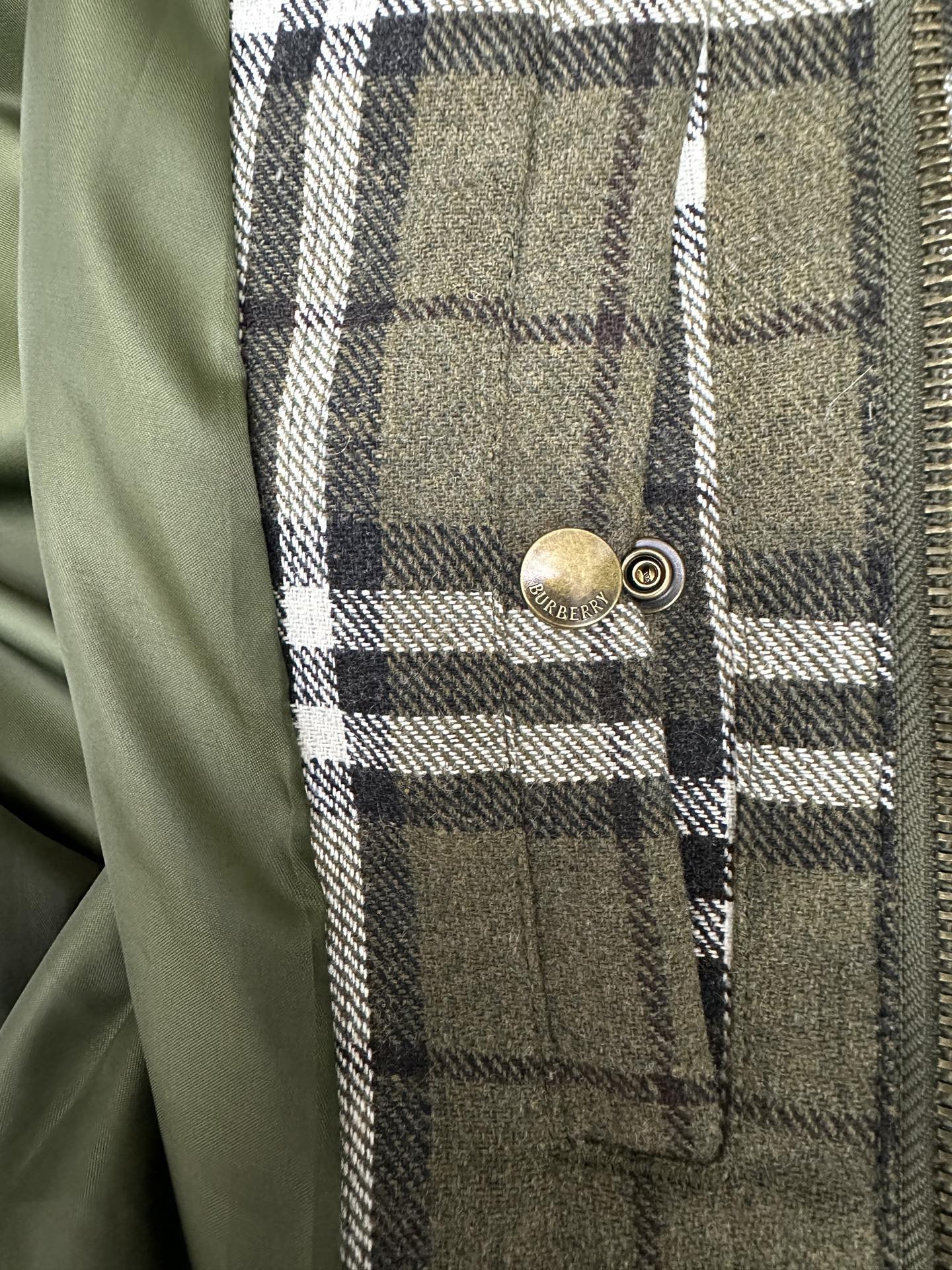 Olive green plaid jacket chest pocket with brass snap button detail