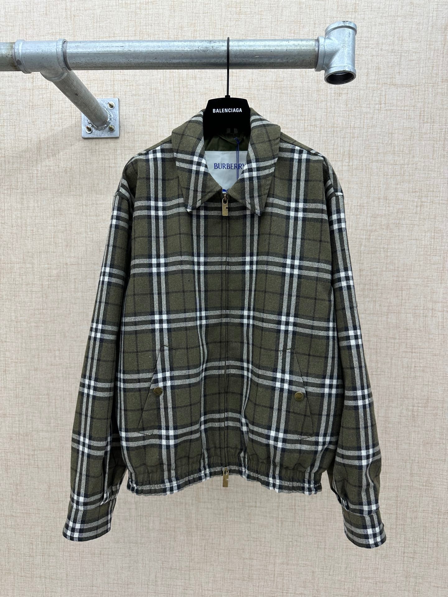 Olive green plaid zip jacket with stand collar, front pockets, and elastic cuffs