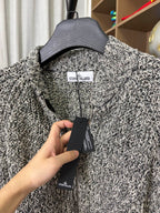 Textured black-and-white speckled zip jacket with neck tag label
