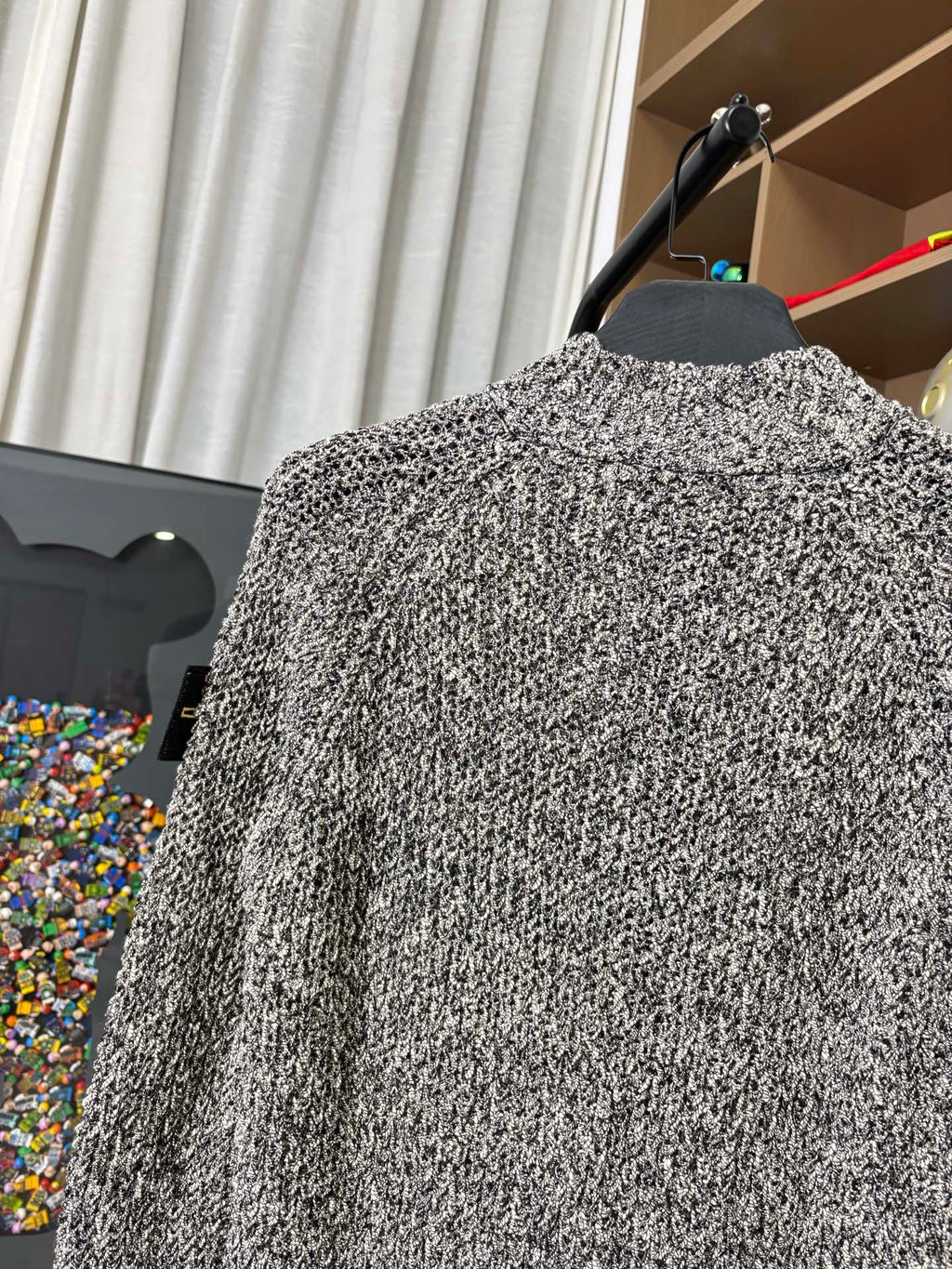 Textured black-and-white speckled jacket back view on hanger