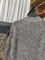 Textured black-and-white speckled jacket back view on hanger