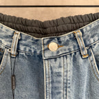 Balenciaga denim pants close-up: button fly, belt loops, and stitched pockets