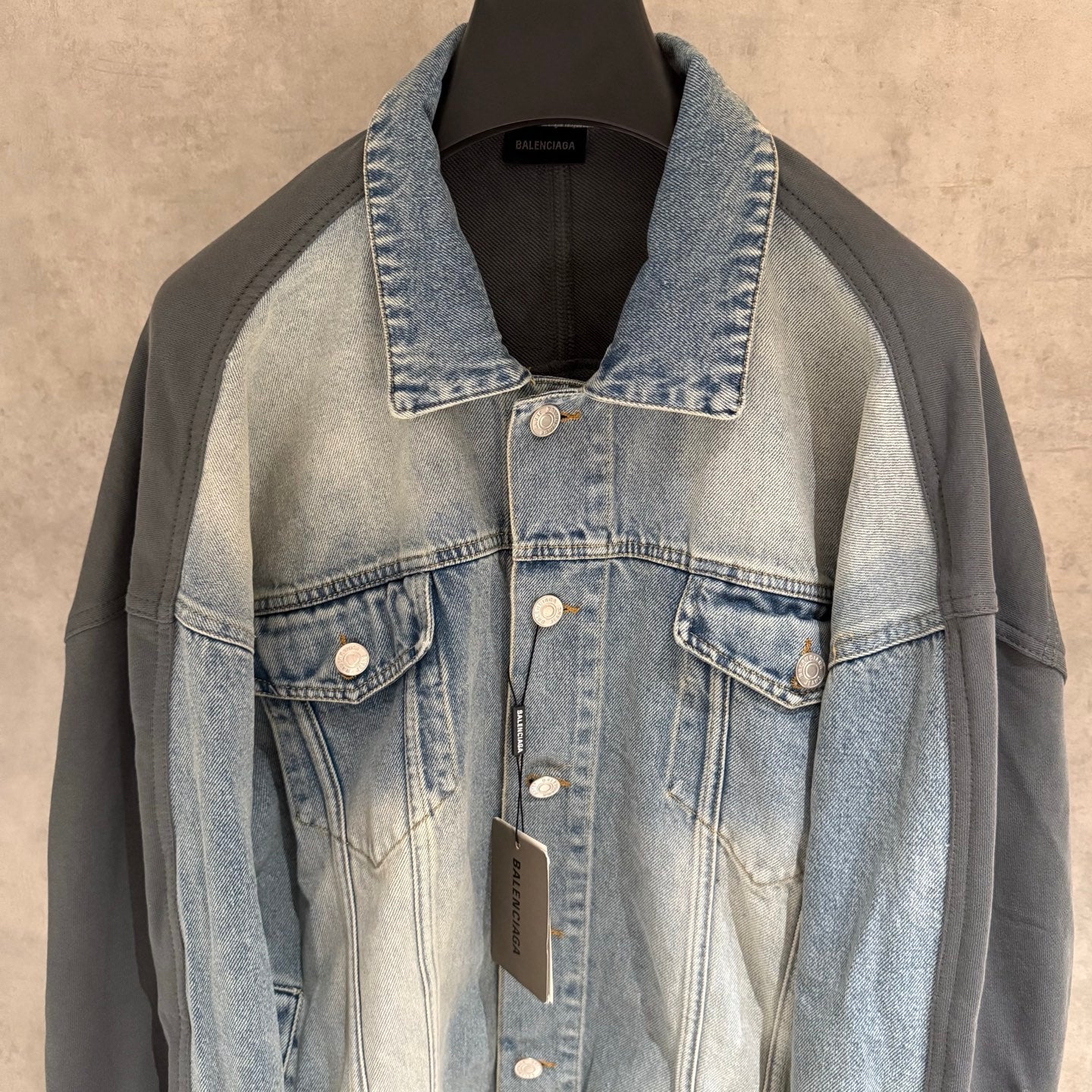 Denim-and-charcoal jacket front with spread collar and chest flap pockets