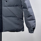 Moncler puffer jacket front close-up, dark gray quilted panels with elastic cuff