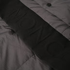 Long puffer jacket fabric close-up with button placket and seam detail
