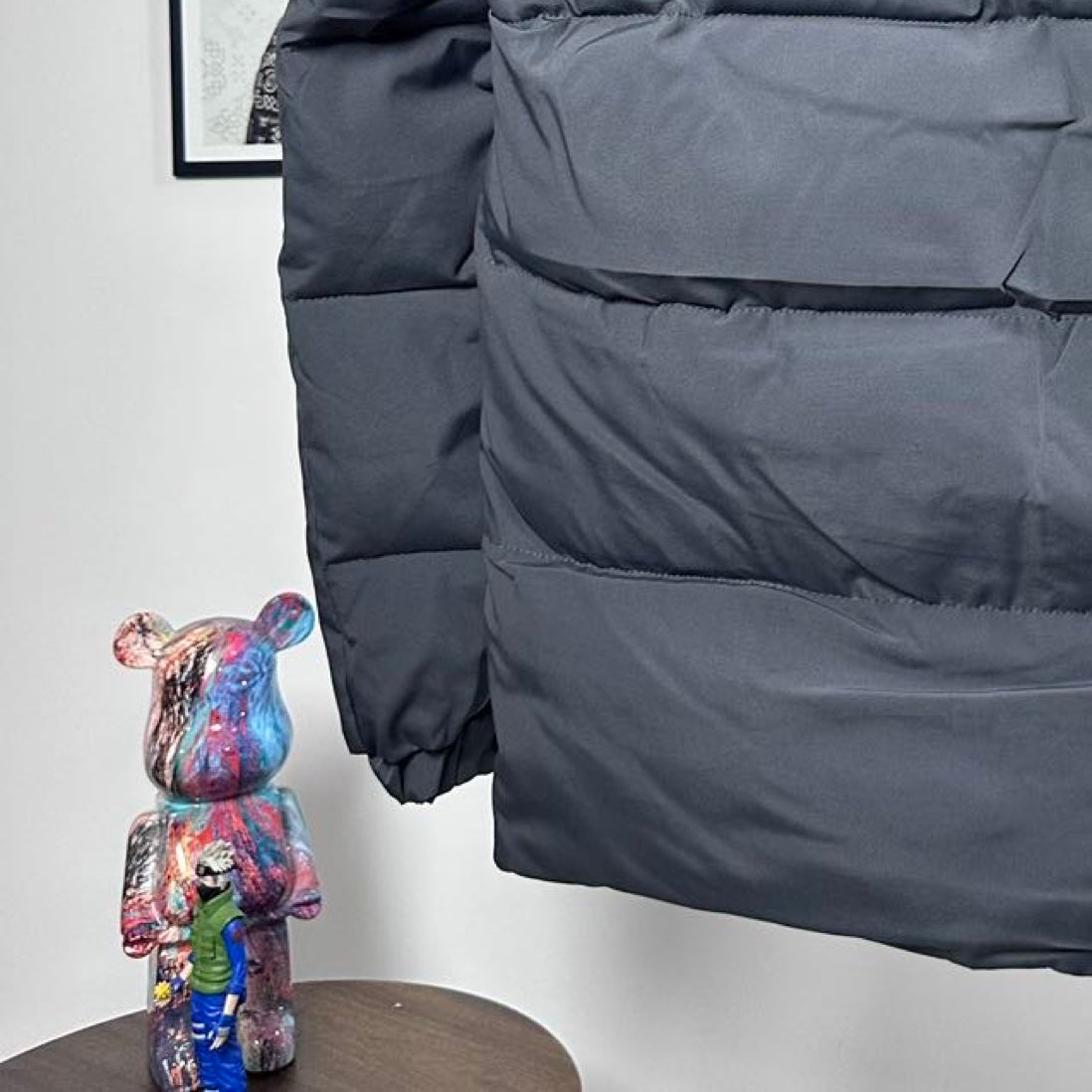 Moncler long puffer jacket lower body close-up, dark gray, quilted panels and elastic cuff