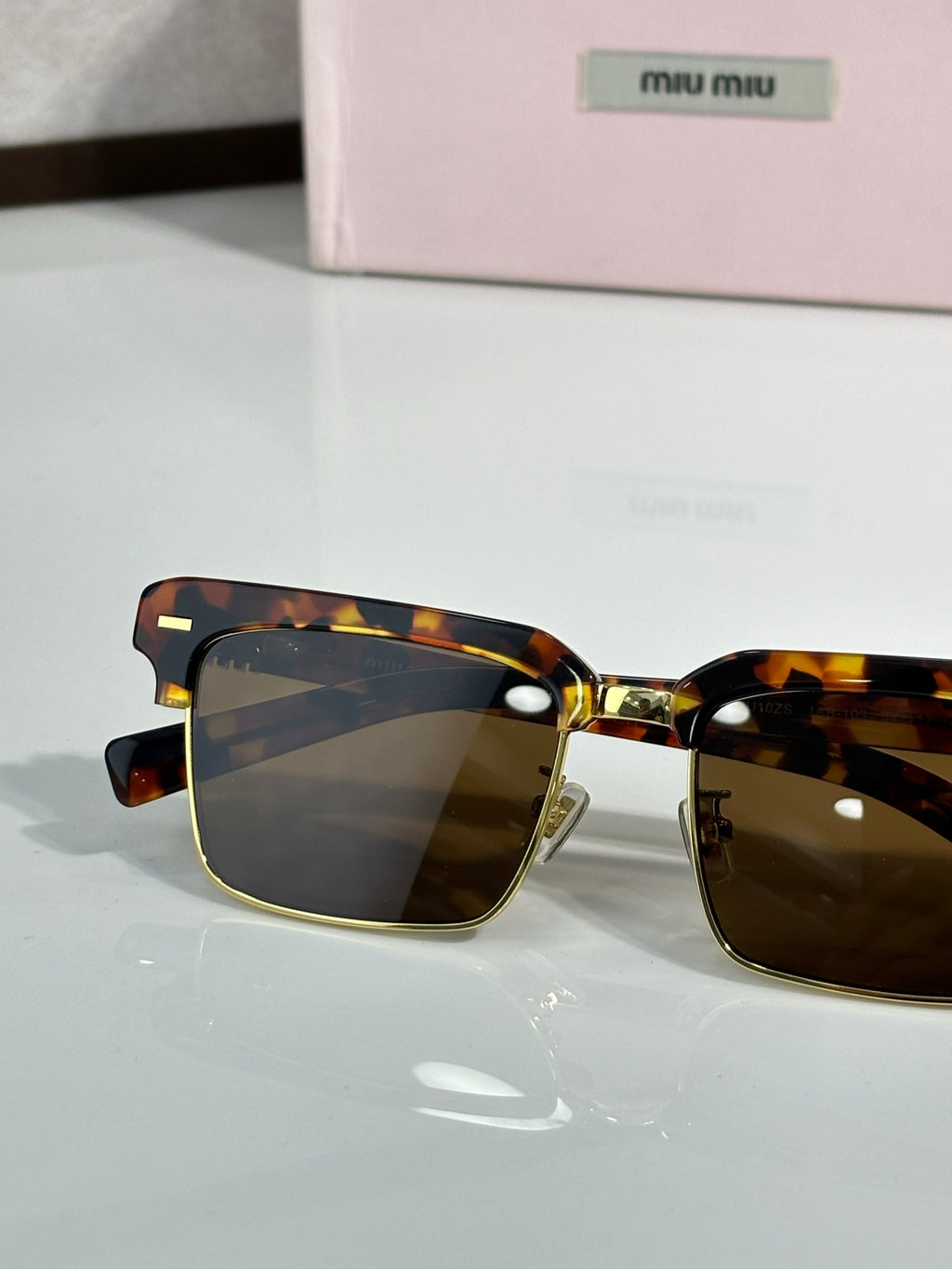 Square sunglasses with tortoiseshell frame and dark lenses, gold bridge, close front view