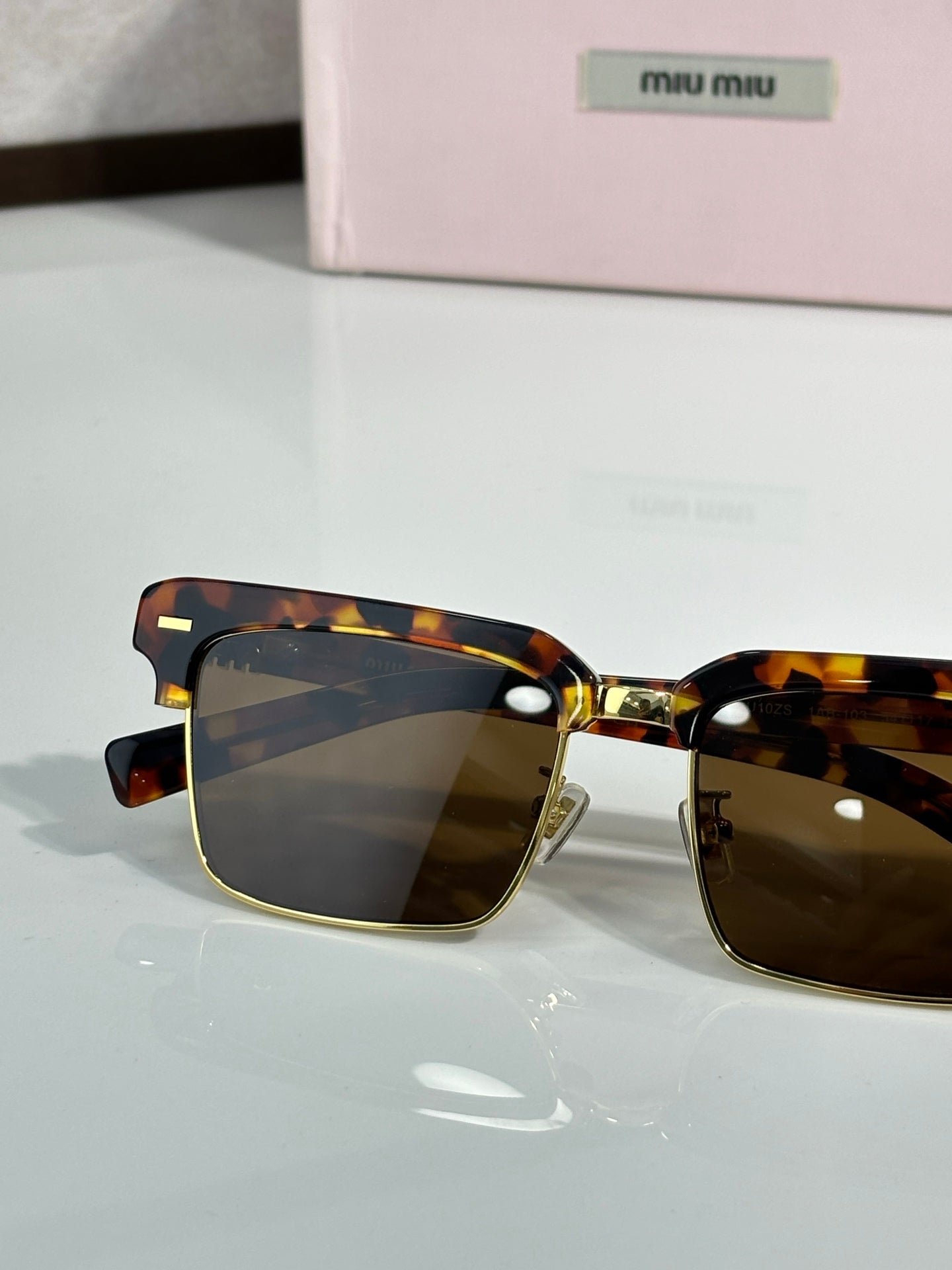 Square sunglasses with tortoiseshell frame and dark lenses, gold bridge, close front view