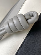 Loewe bag handle detail with braided leather grip on light gray strap