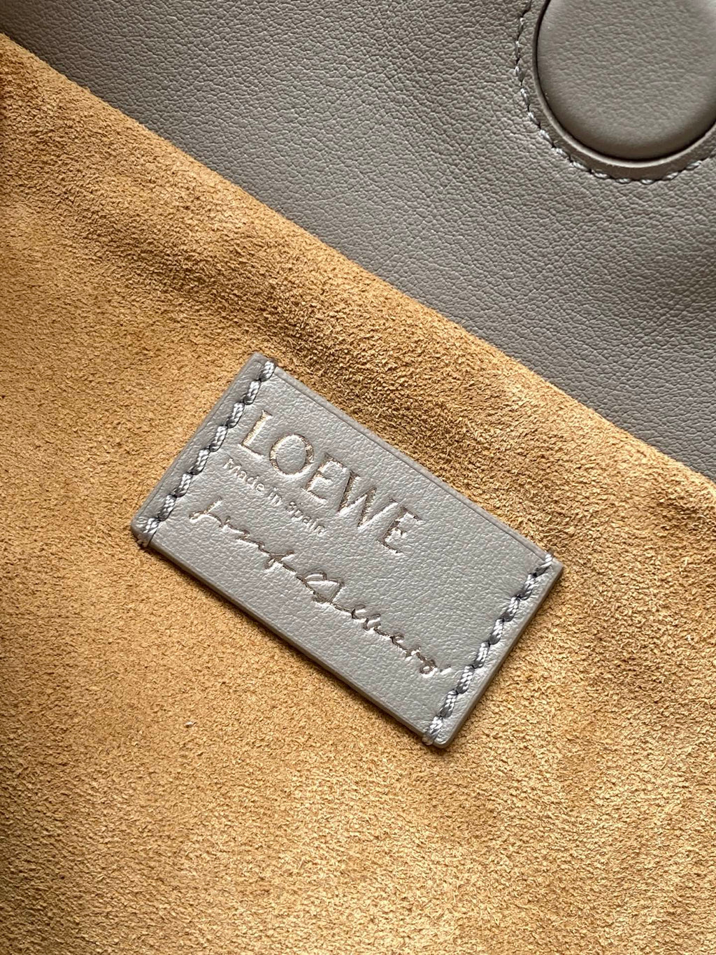 Loewe bag suede interior label with stitched Loewe logo and tan leather texture