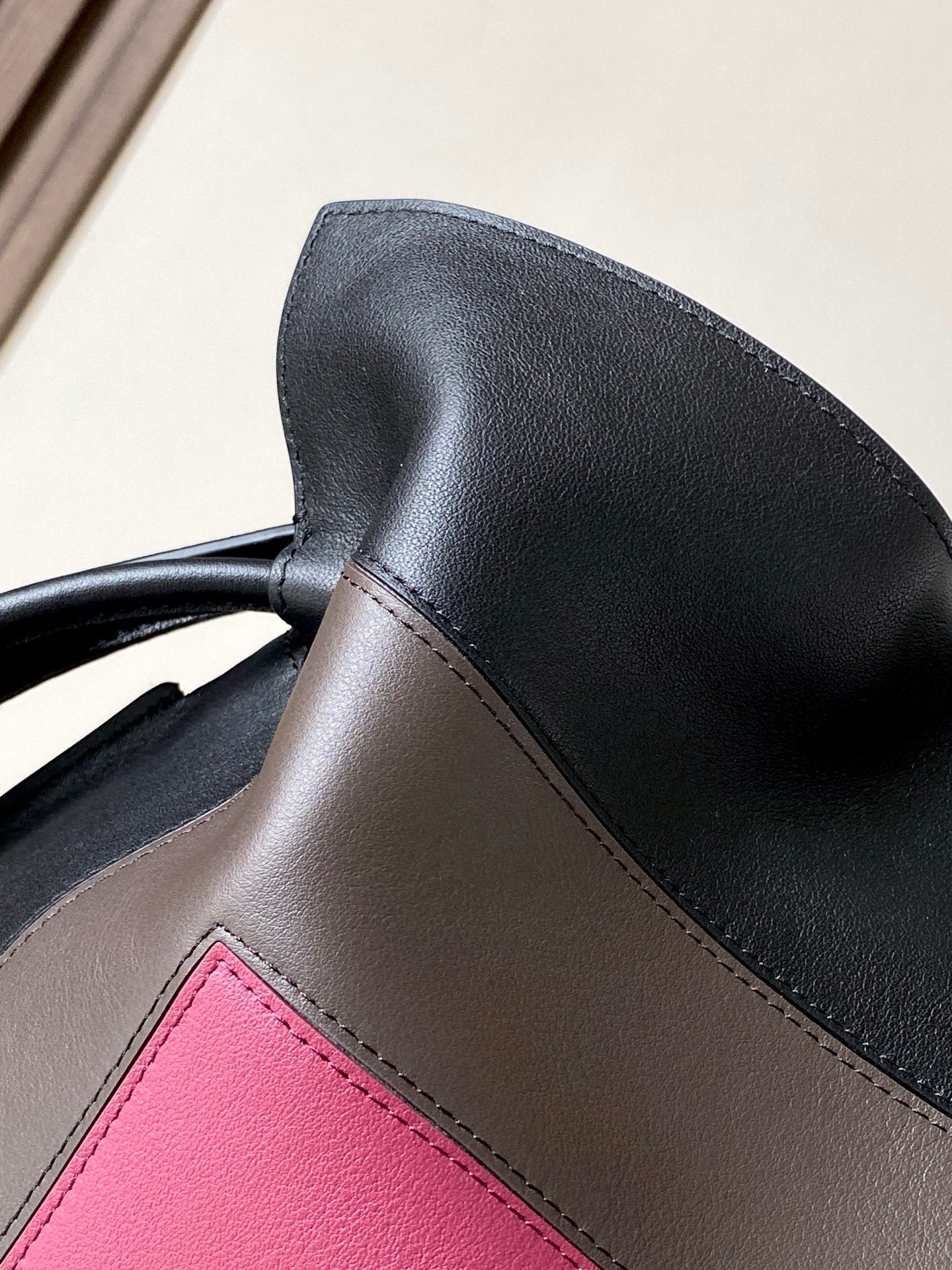 Loewe leather bag corner with black flap edge and pink stitched insert