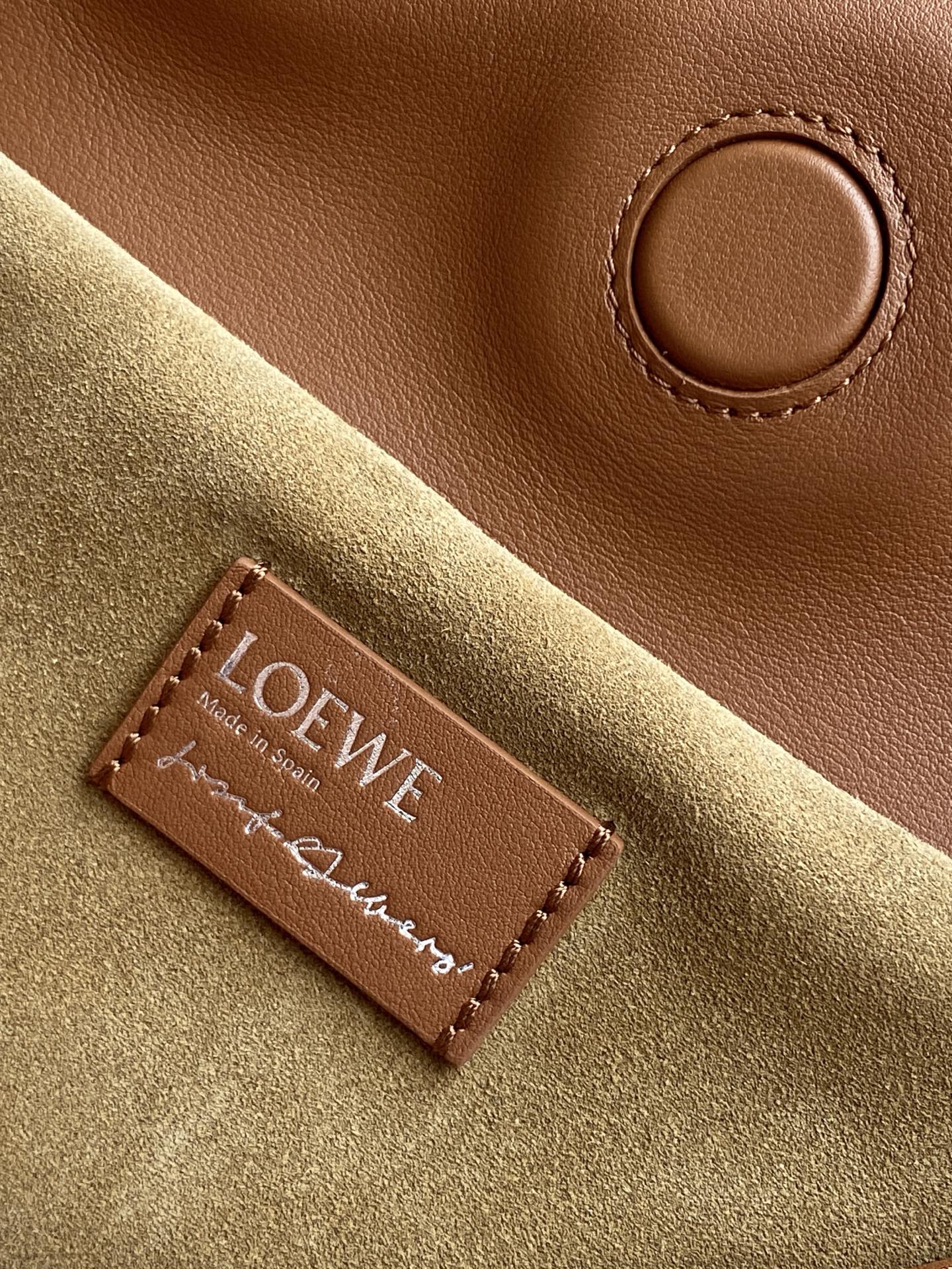 Loewe bag suede label patch with LOEWE branding on tan and olive fabric