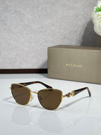 Brown cat-eye sunglasses with gold metal accents and amber gradient lenses.