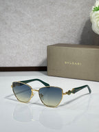 Green cat-eye sunglasses with gold metal accents and light gradient lenses.