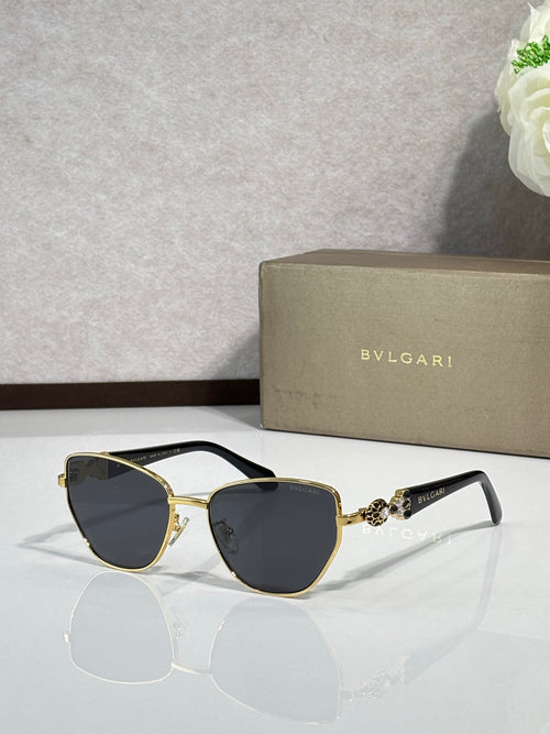 Black cat-eye sunglasses with gold metal accents and dark gradient lenses.