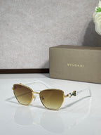 White cat-eye sunglasses with gold metal accents and light amber gradient lenses.
