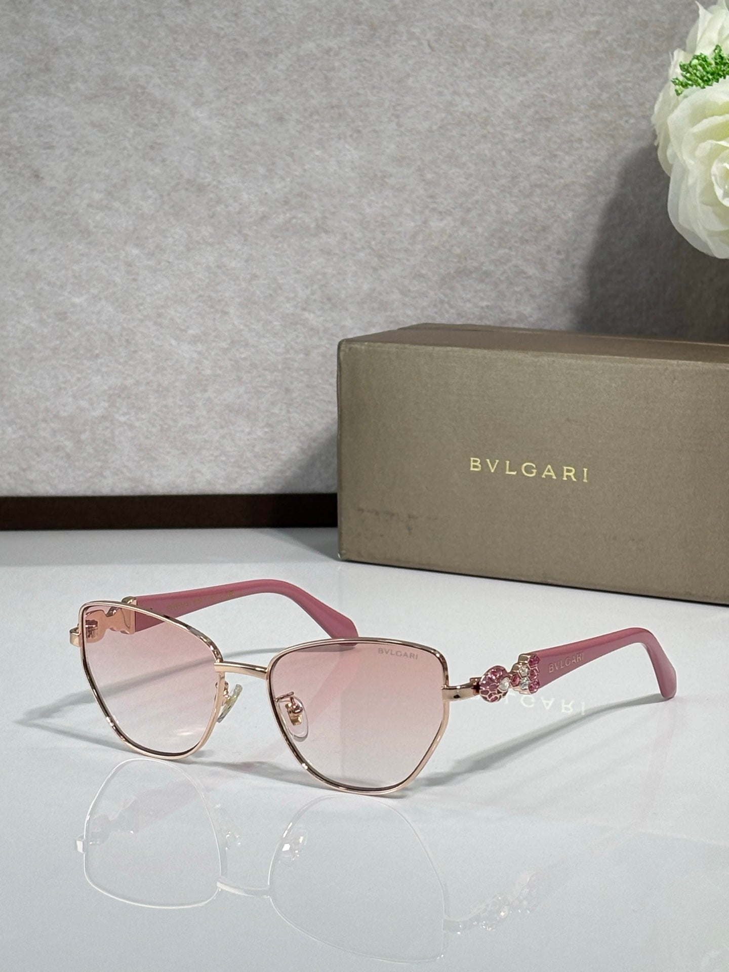 Pink/red cat-eye sunglasses with gold metal accents and soft pink gradient lenses.