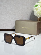Bvlgari sunglasses with black frames and brown tinted lenses, jeweled temple detail.