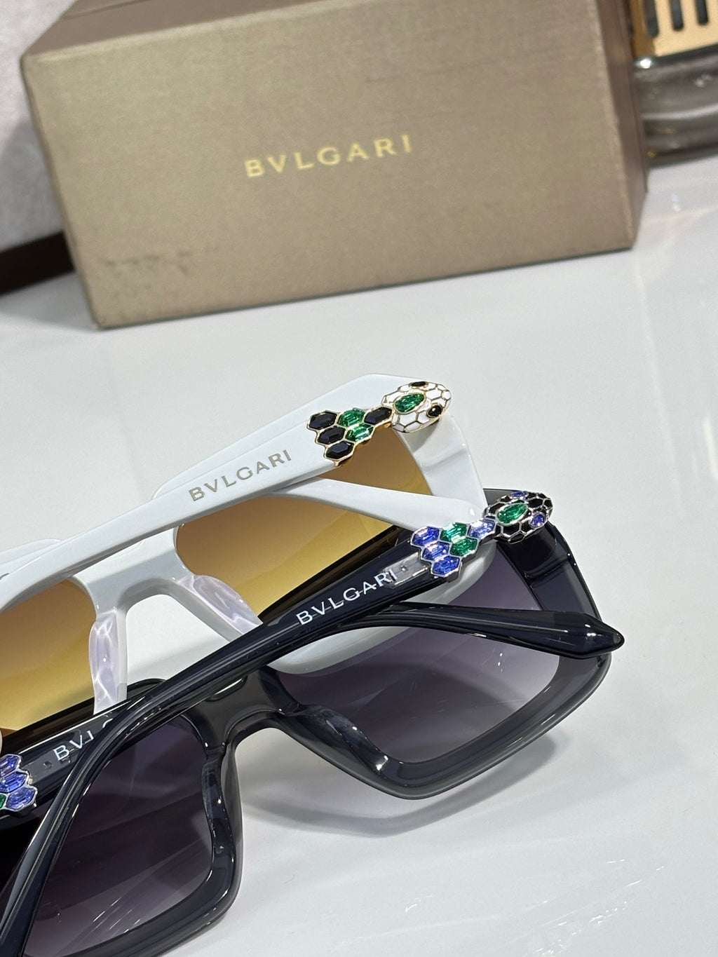 Bvlgari sunglasses with black and white frames, jeweled temple detail and tinted lenses.